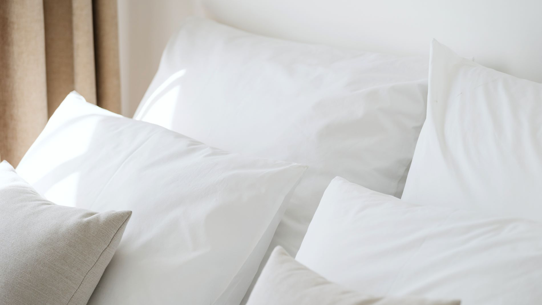 Lots of white pillows in a bed