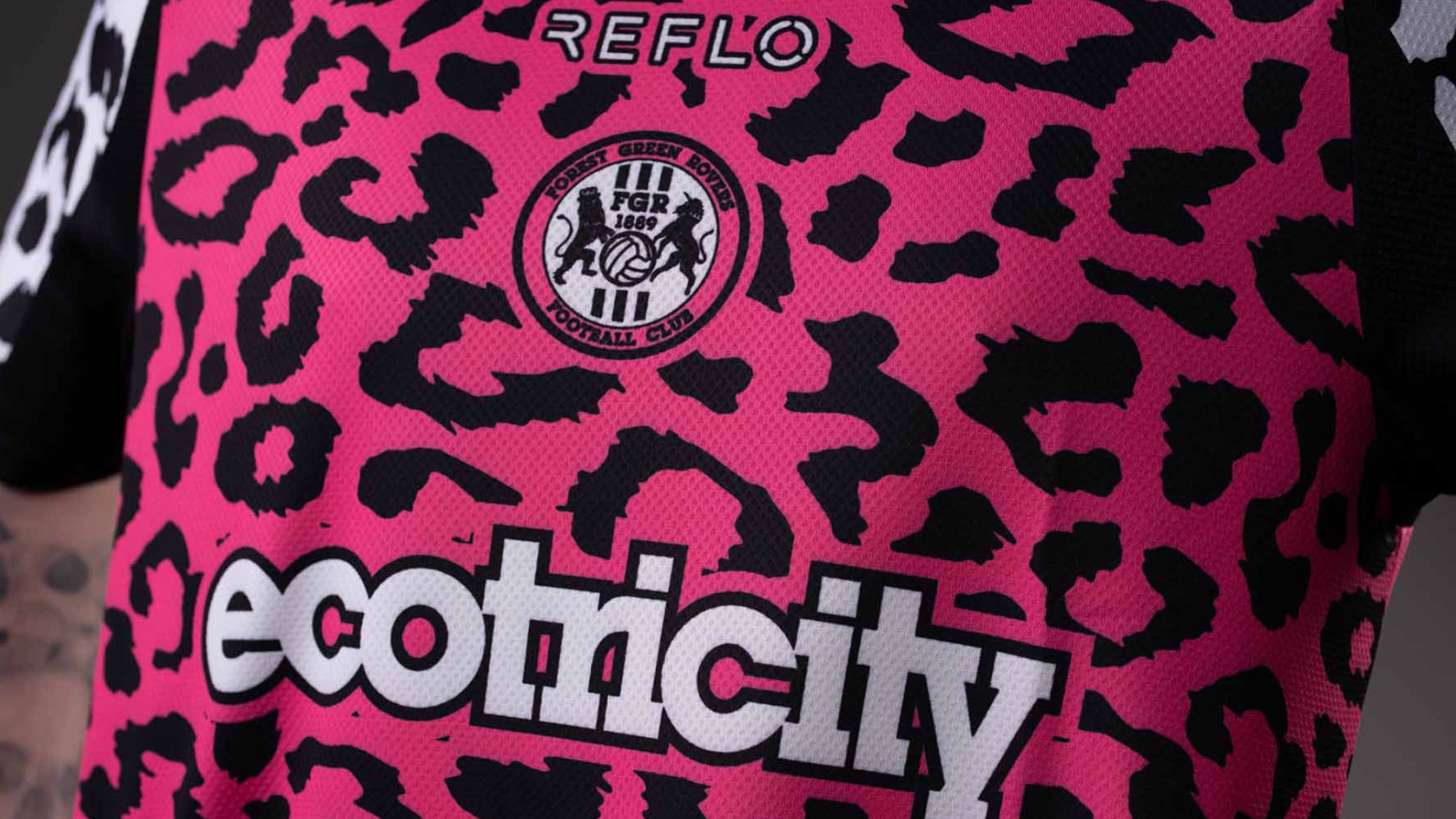 Detailaufnahme eines pink-schwarzen Trikots mit Leopardenmuster des Forest Green Rovers Football Club mit dem Logo von Ecotricity.