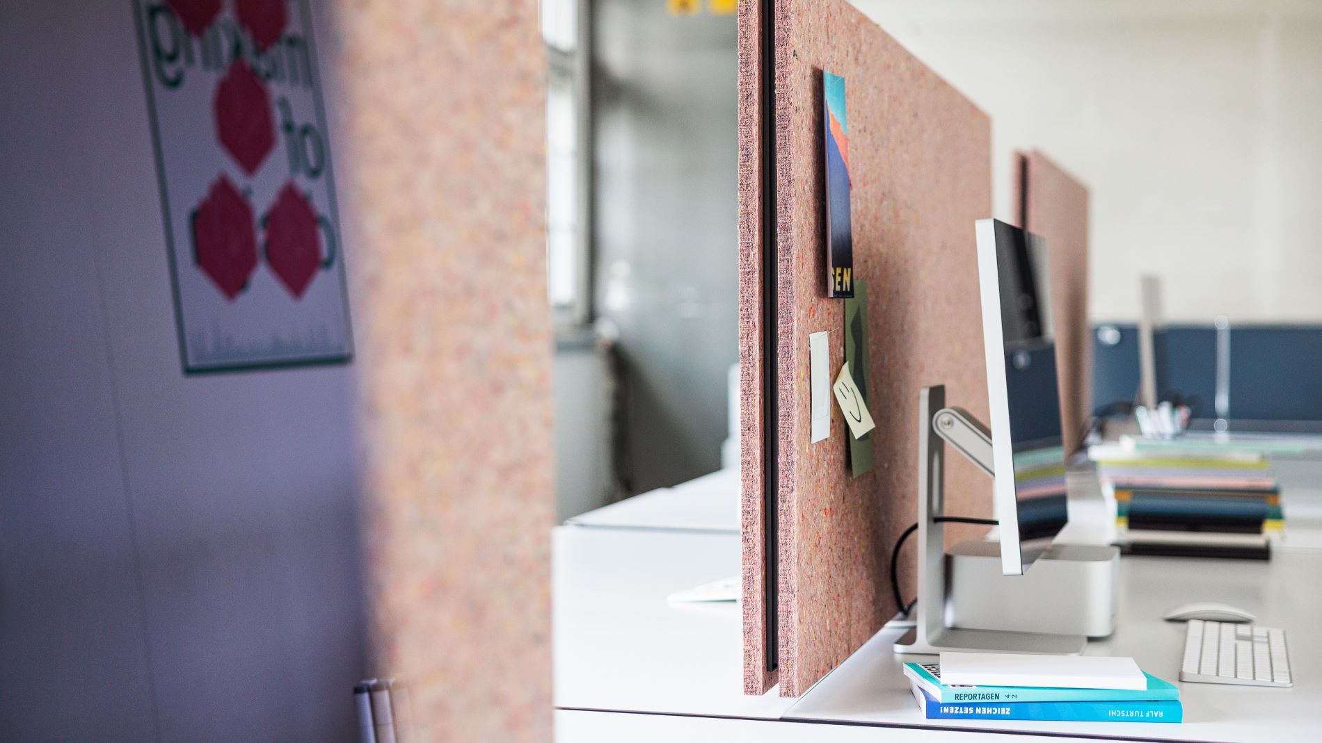 Desk with cork partition and computer in a creative office