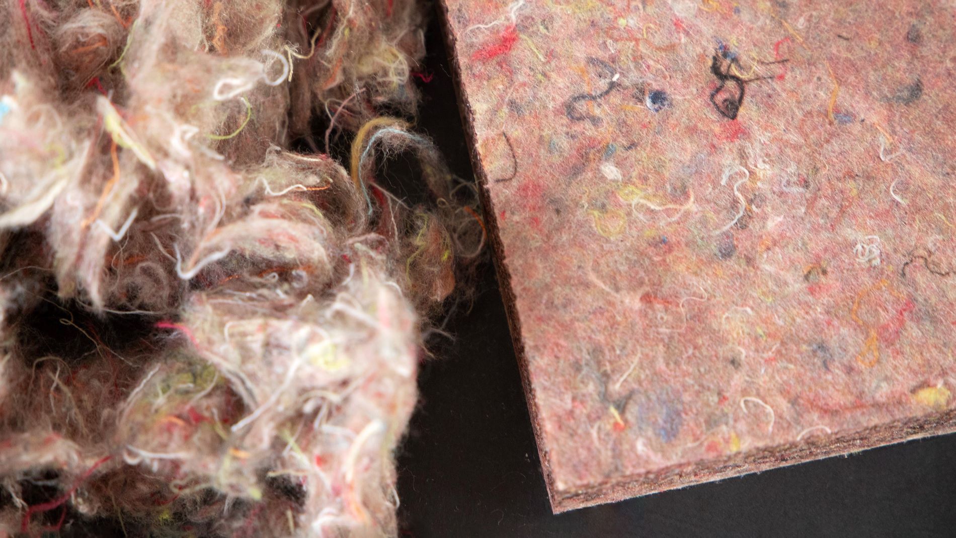 Close-up of recycled textile fibres and compressed acoustic panel made from fabric waste