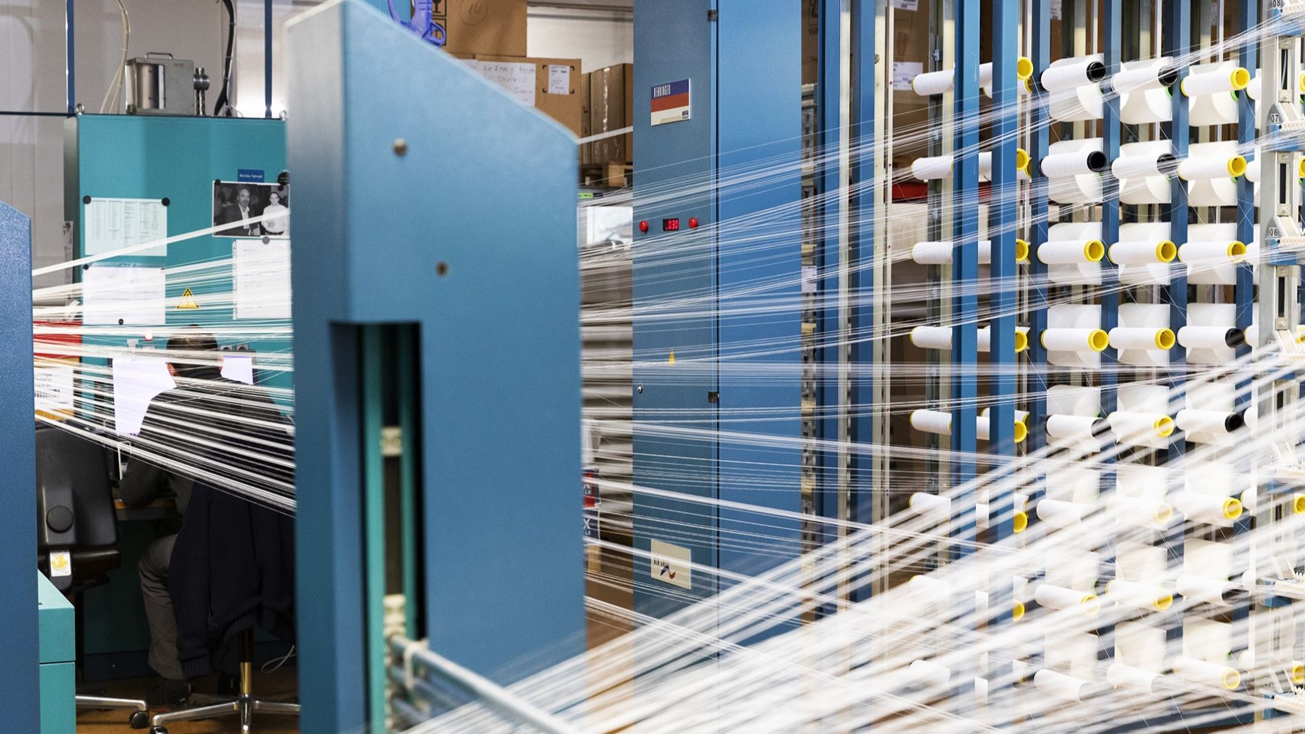 Production hall with textile machinery and yarn spools
