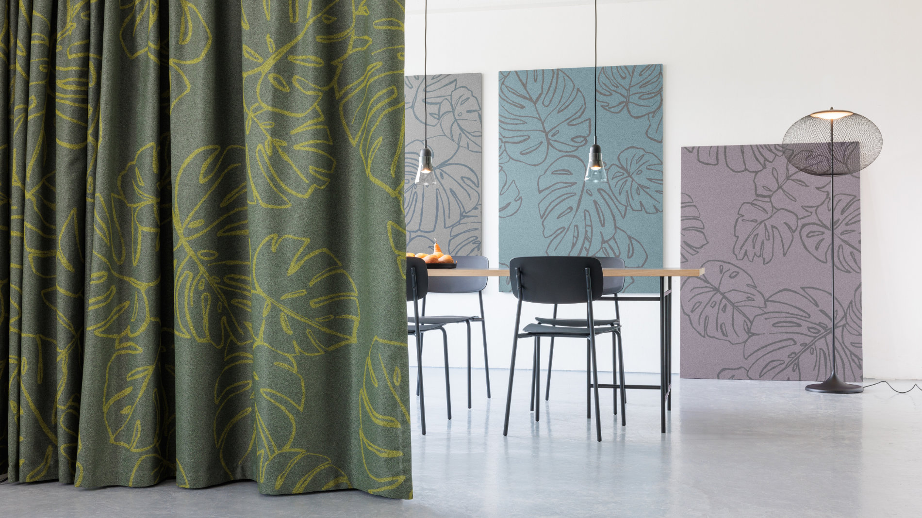 Modern interior with large acoustic curtains and wall panels featuring a tropical leaf pattern, complemented by minimalist furniture and pendant lights.