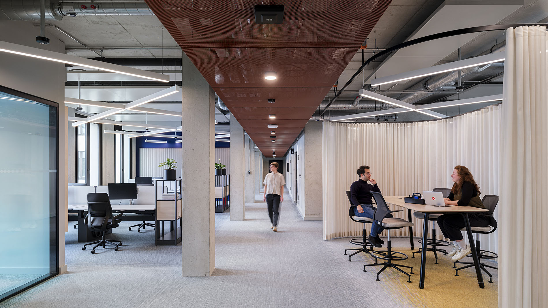 Modern office corridor with open workstations, light curtains, and striking lighting