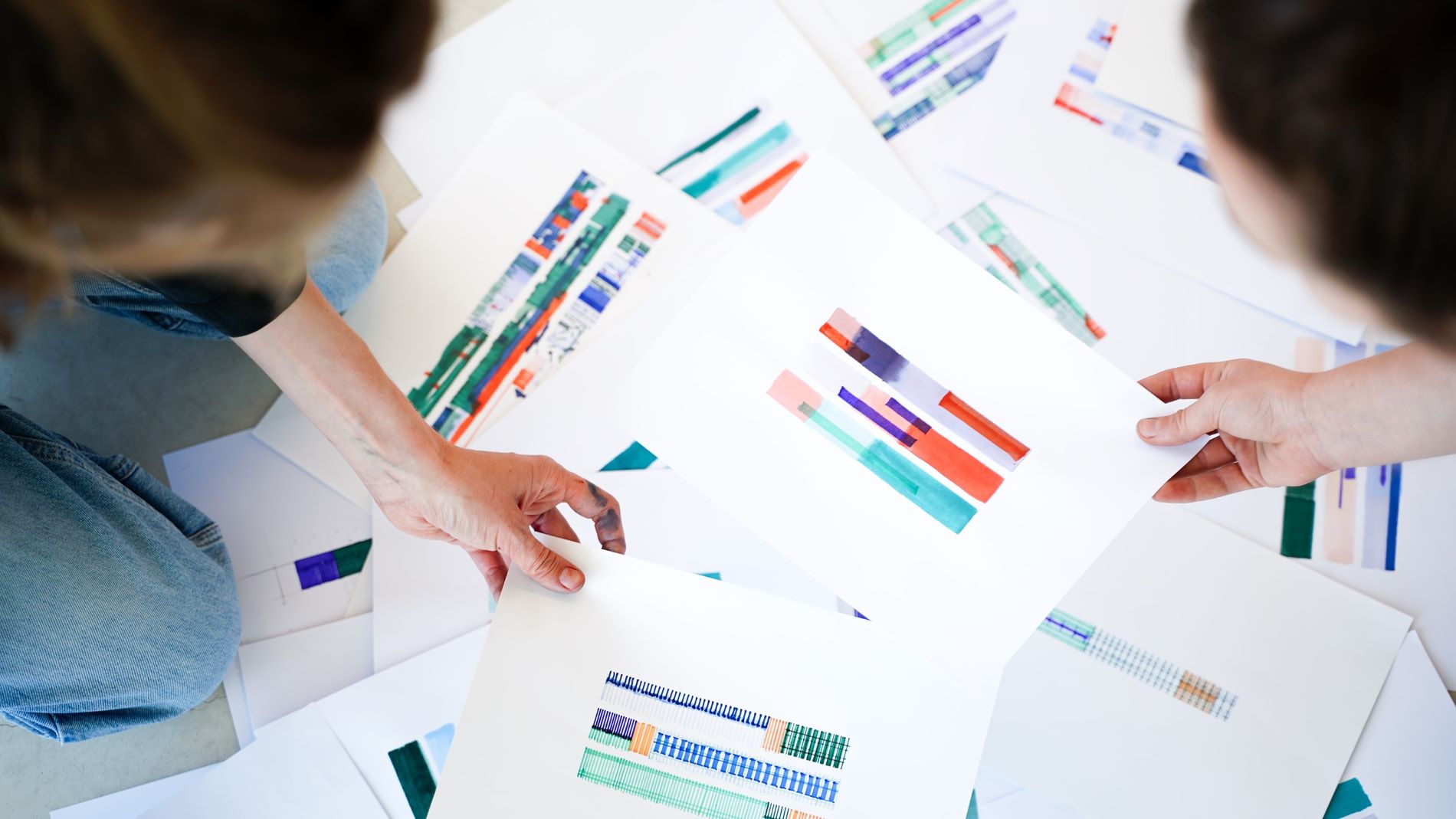 Zwei Frauen über einem Stapel Papiere