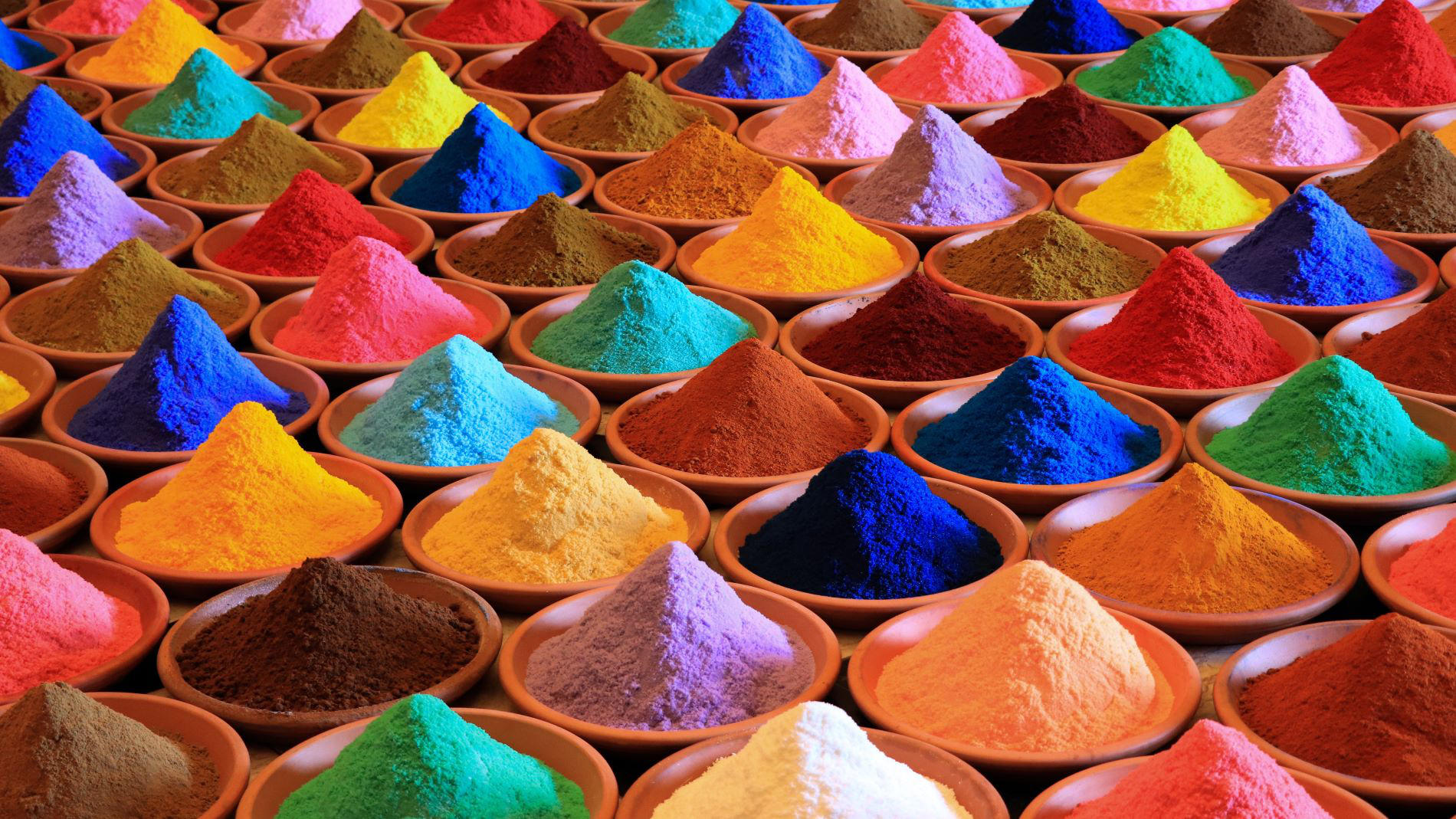 Variety of colourful pigment powders in bowls