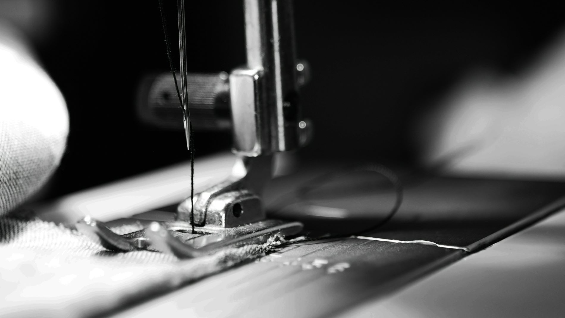 Close-up of a sewing machine needle stitching fabric