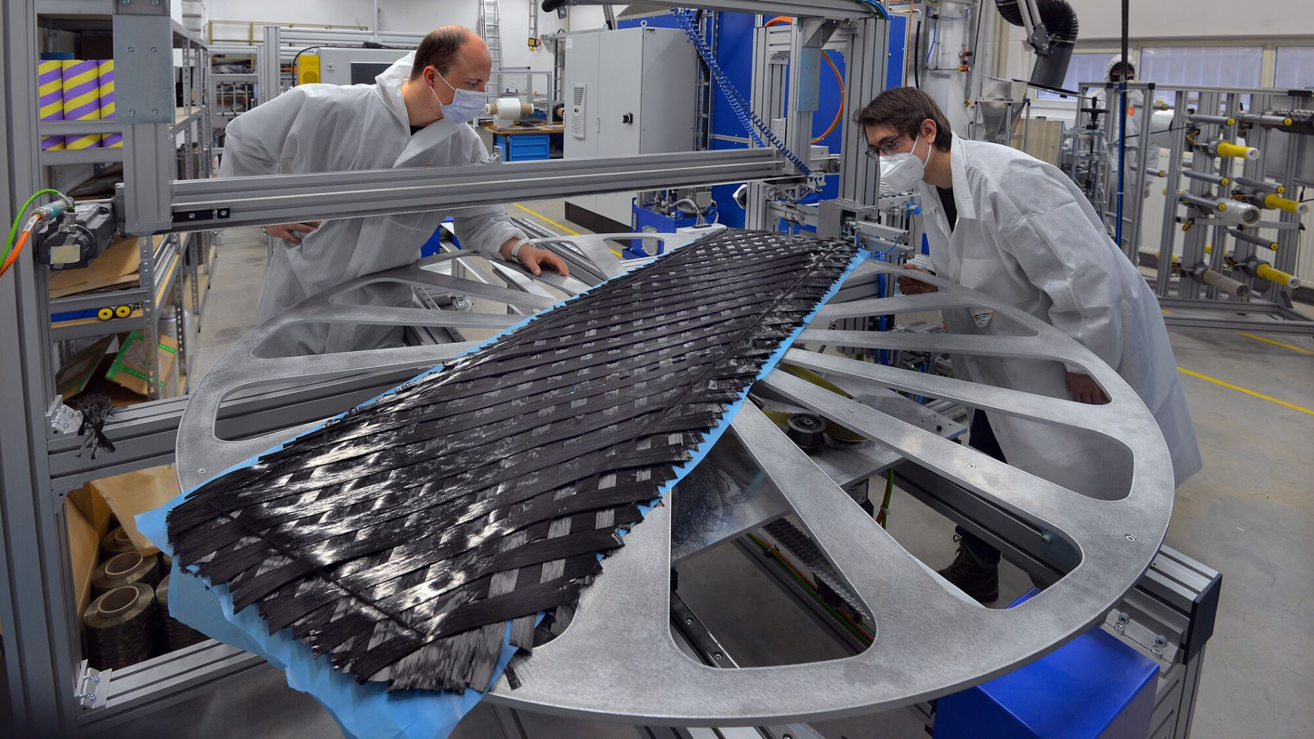 Researchers inspecting carbon fibre component in laboratory