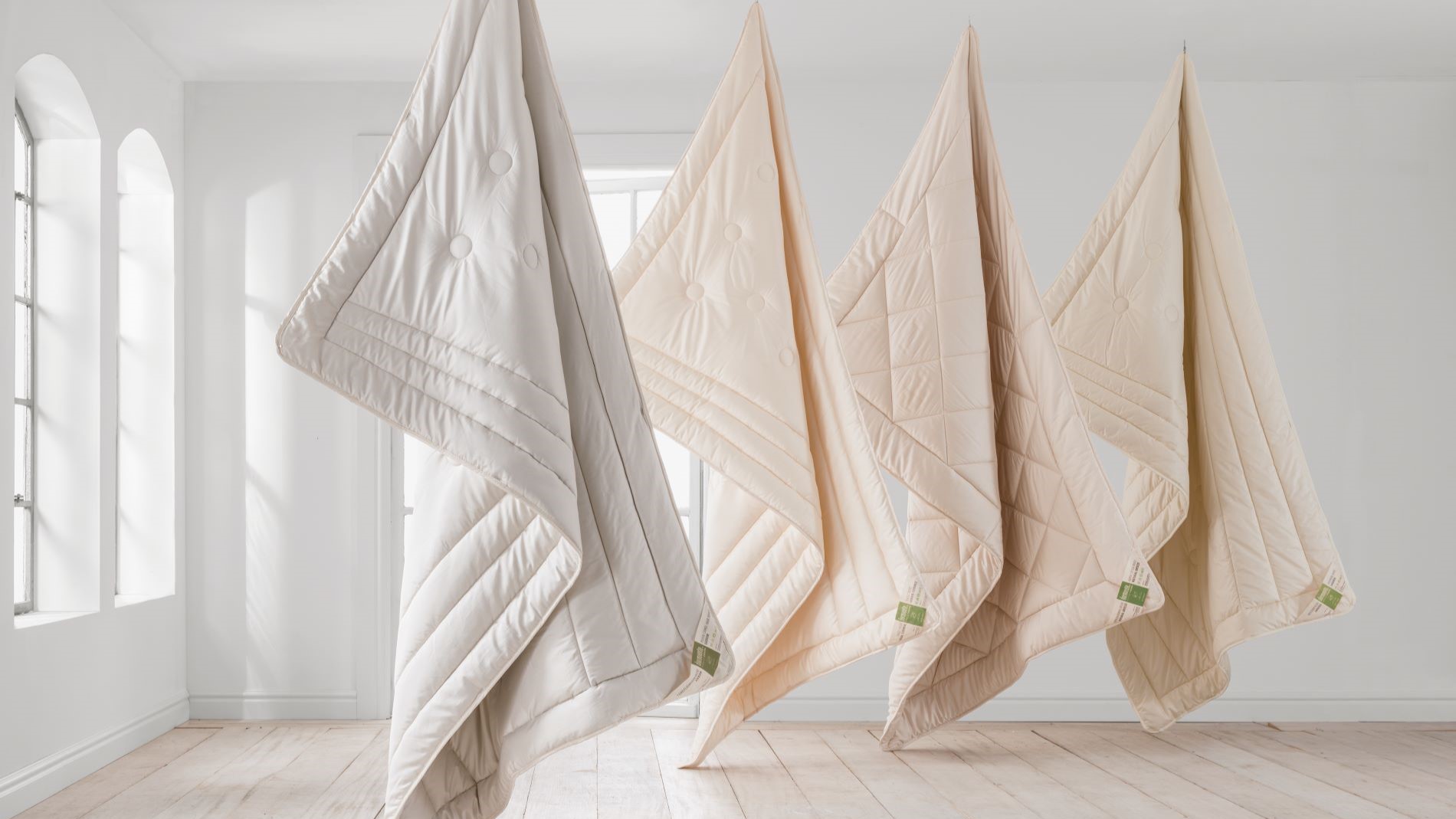 Multiple duvets hanging in bright room