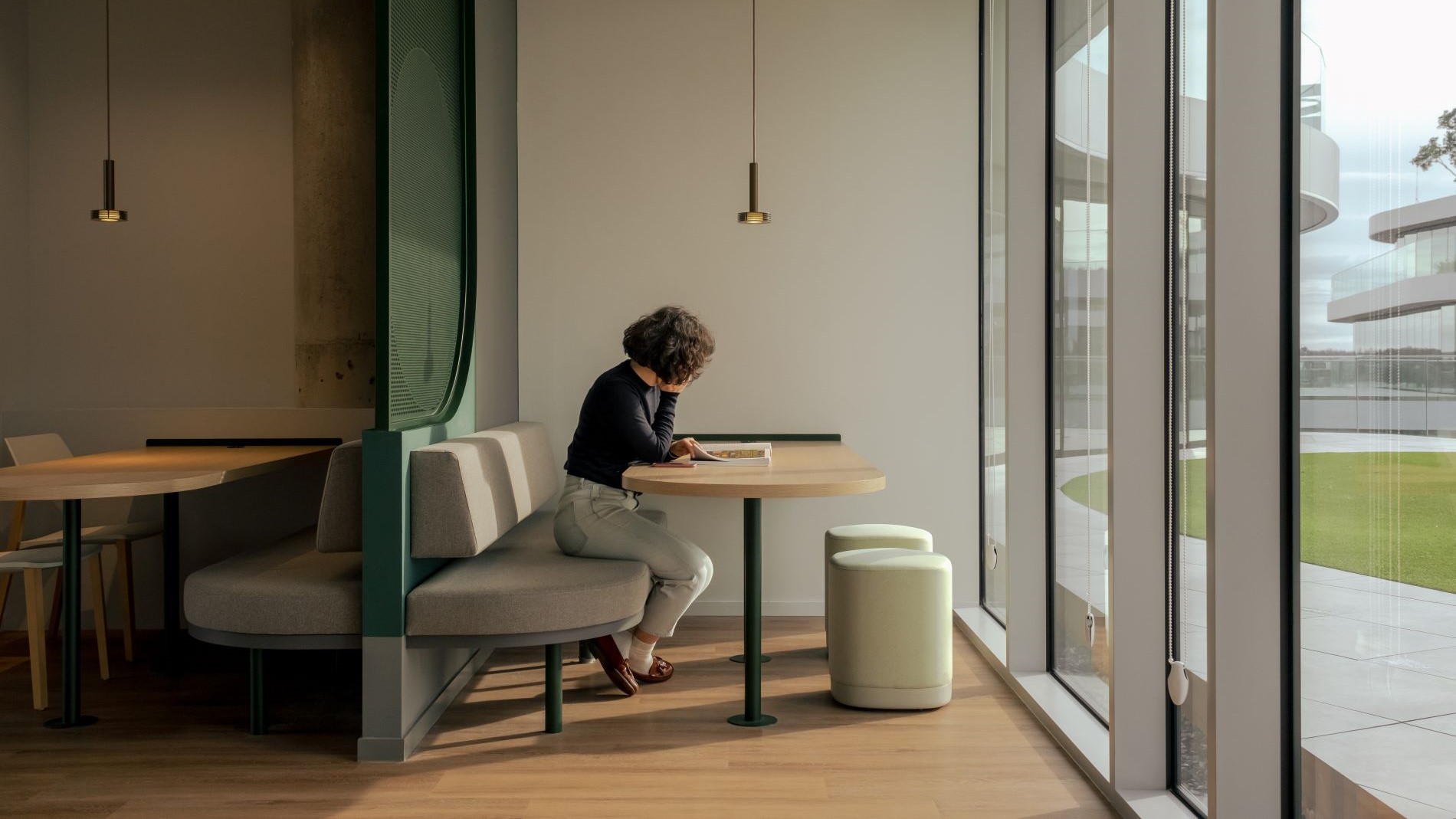 Lounge-Bereich mit Vorhängen und Polstermöbeln und offener Restaurantbereich mit runden Tischen