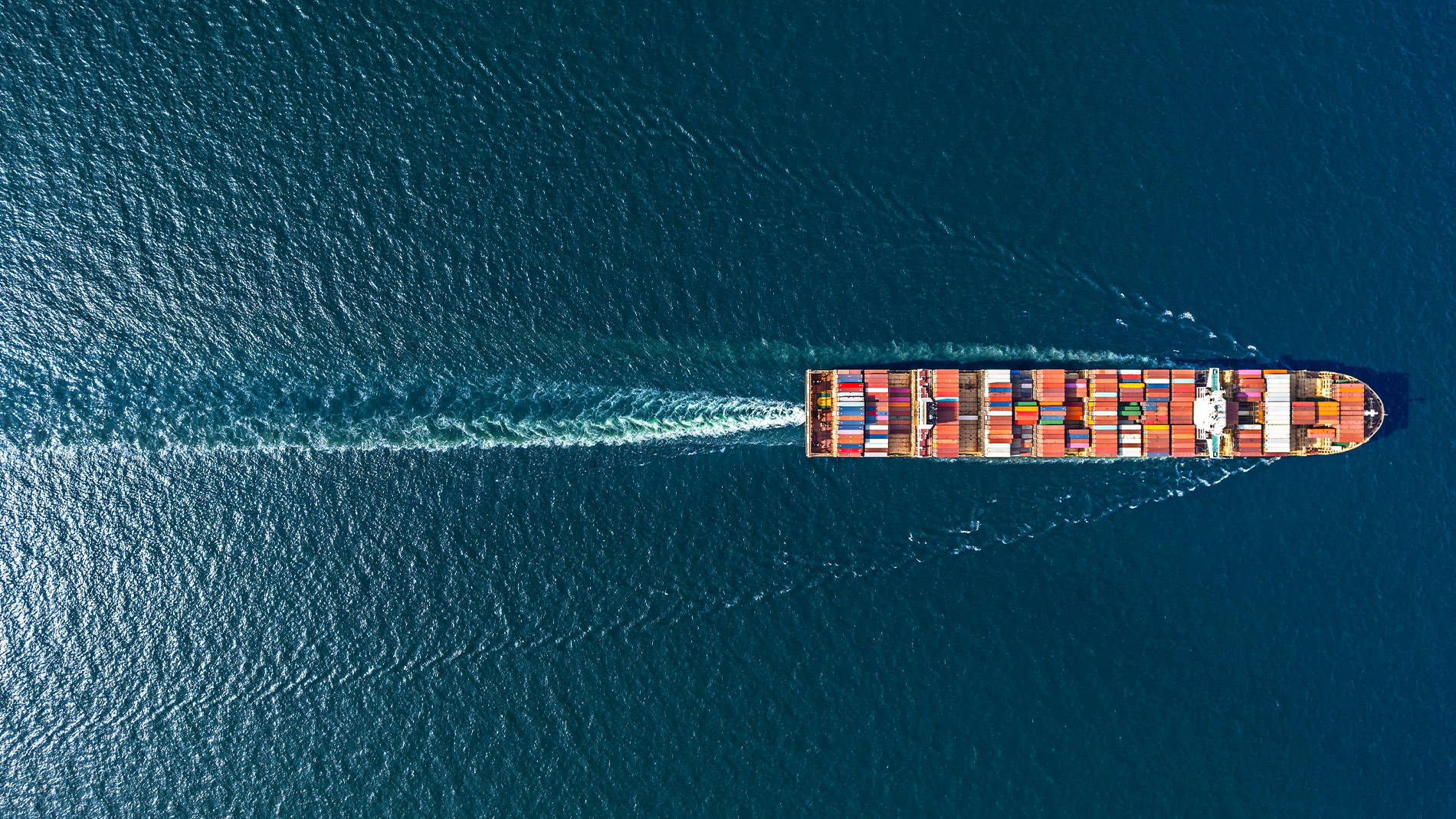 Containerschiff mit bunten Frachtcontainern auf offener See