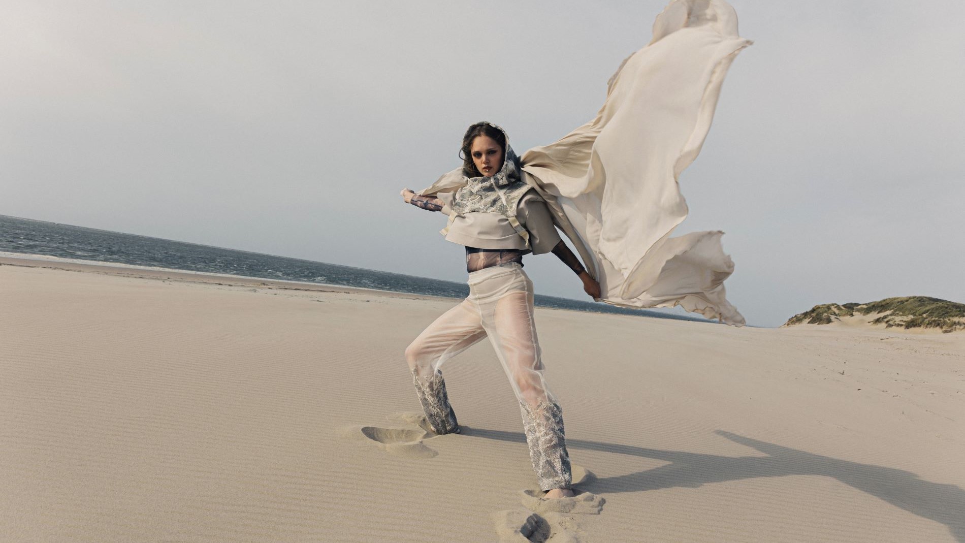 Avant-garde model in light beachwear with flowing fabric