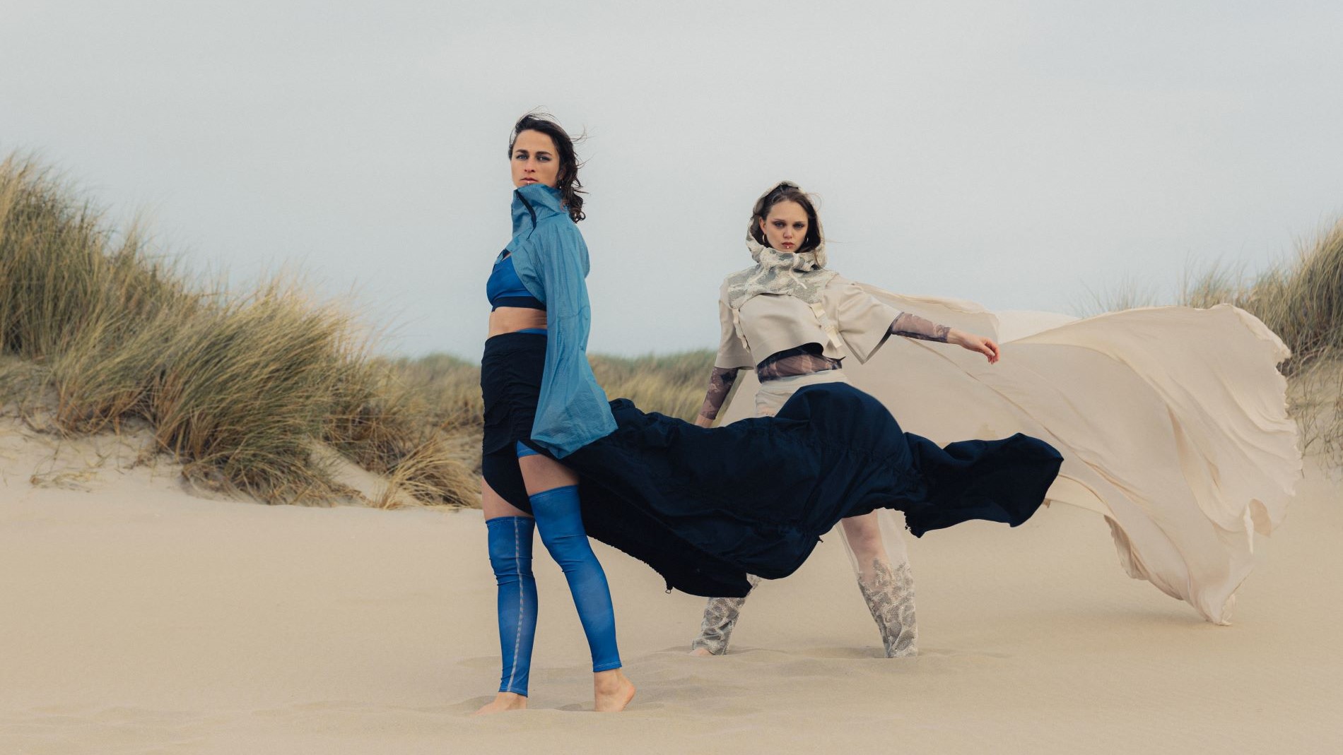 Two models in avant-garde fashion in the dunes
