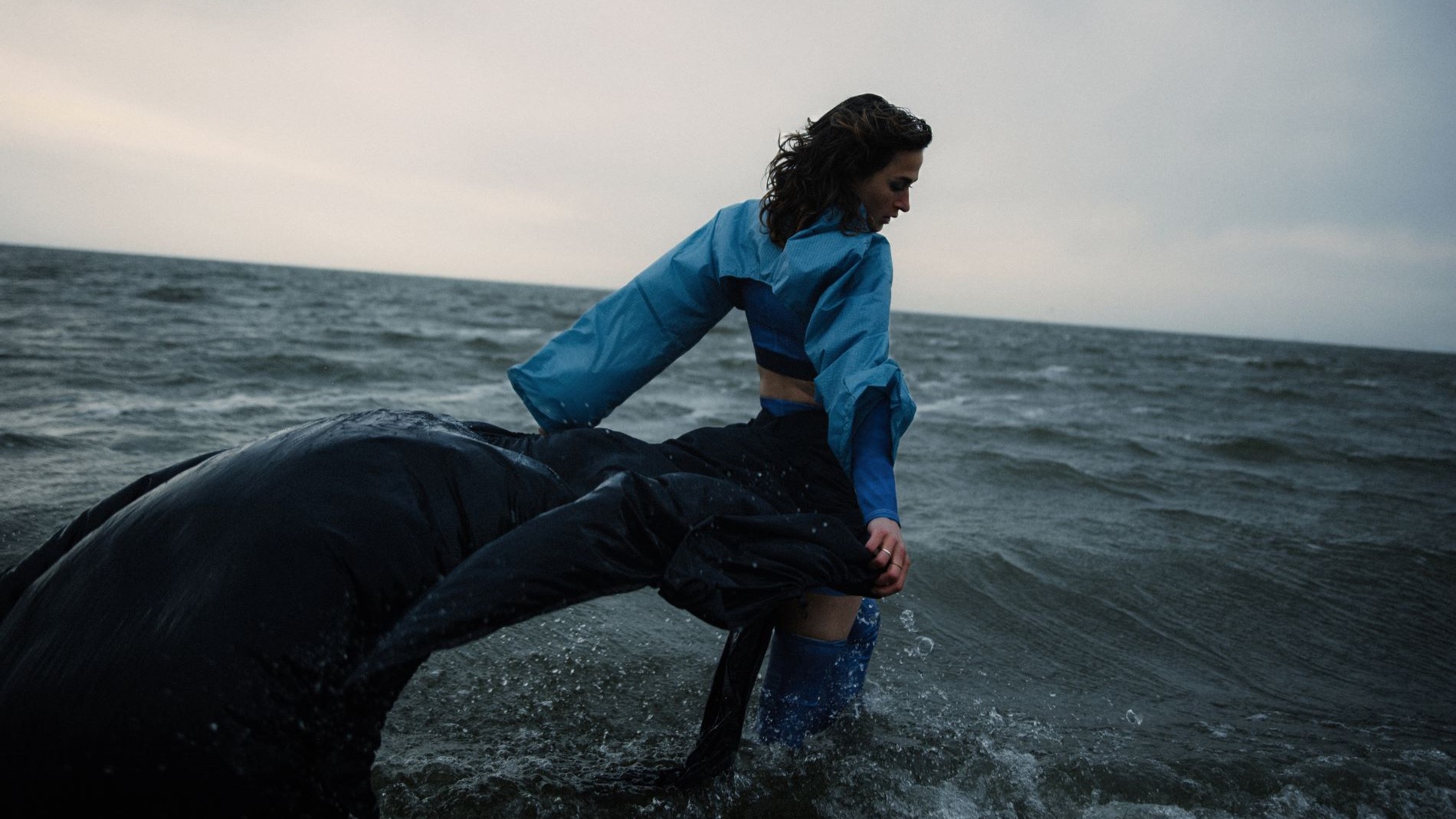 Model in blue fashion in stormy sea