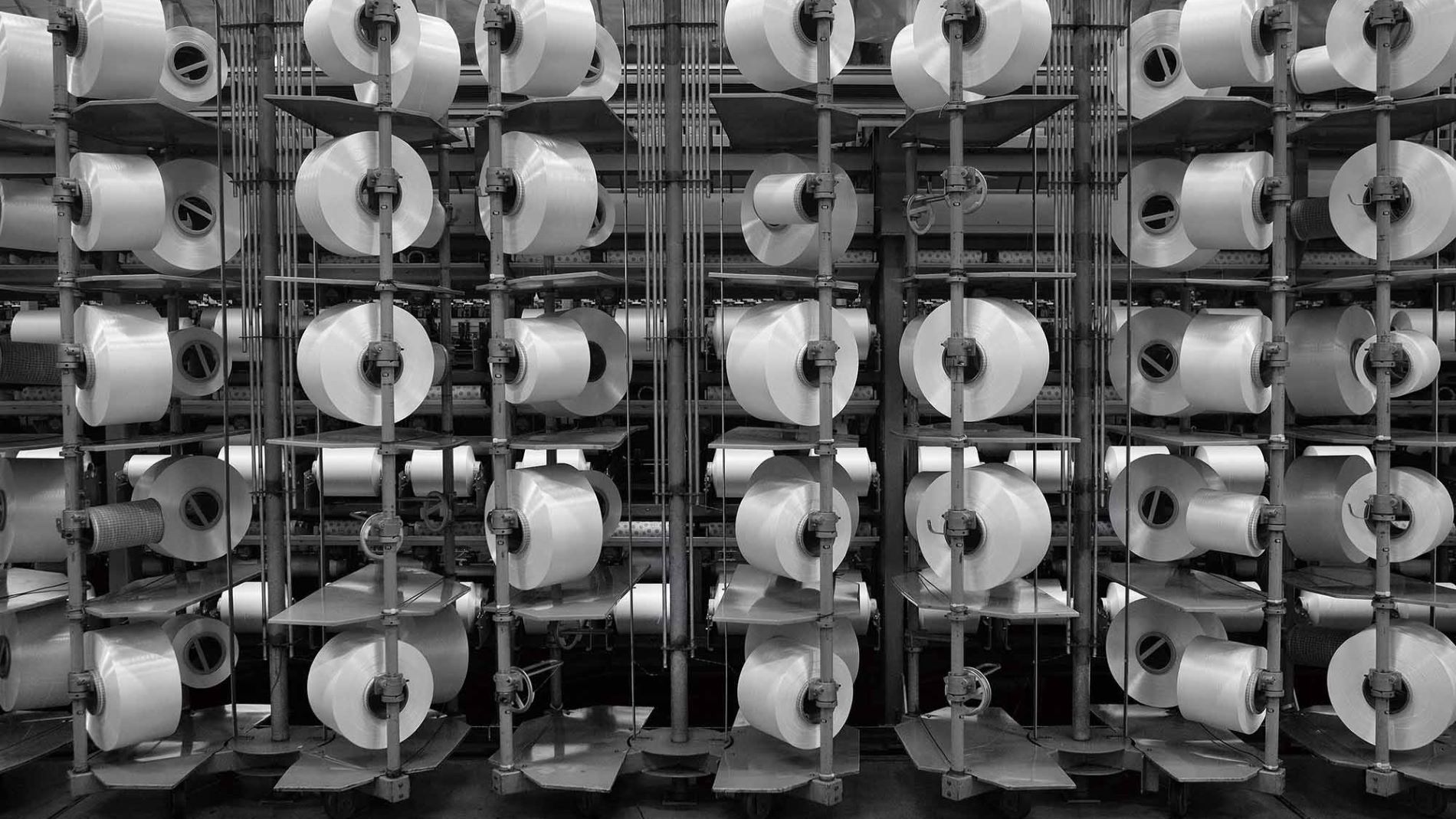 Rows of yarn spools in textile production.