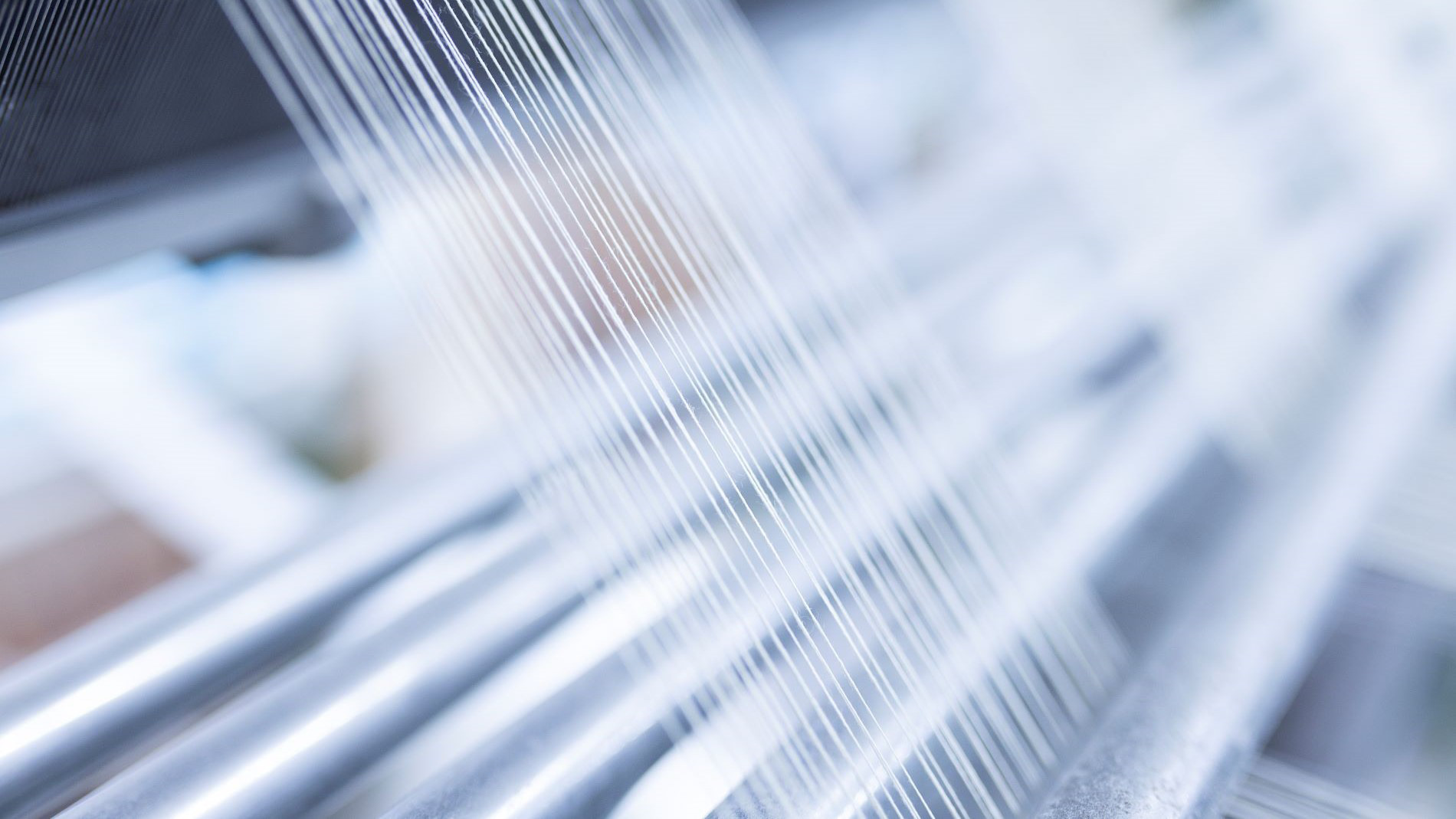 Close-up of fine threads in textile machine
