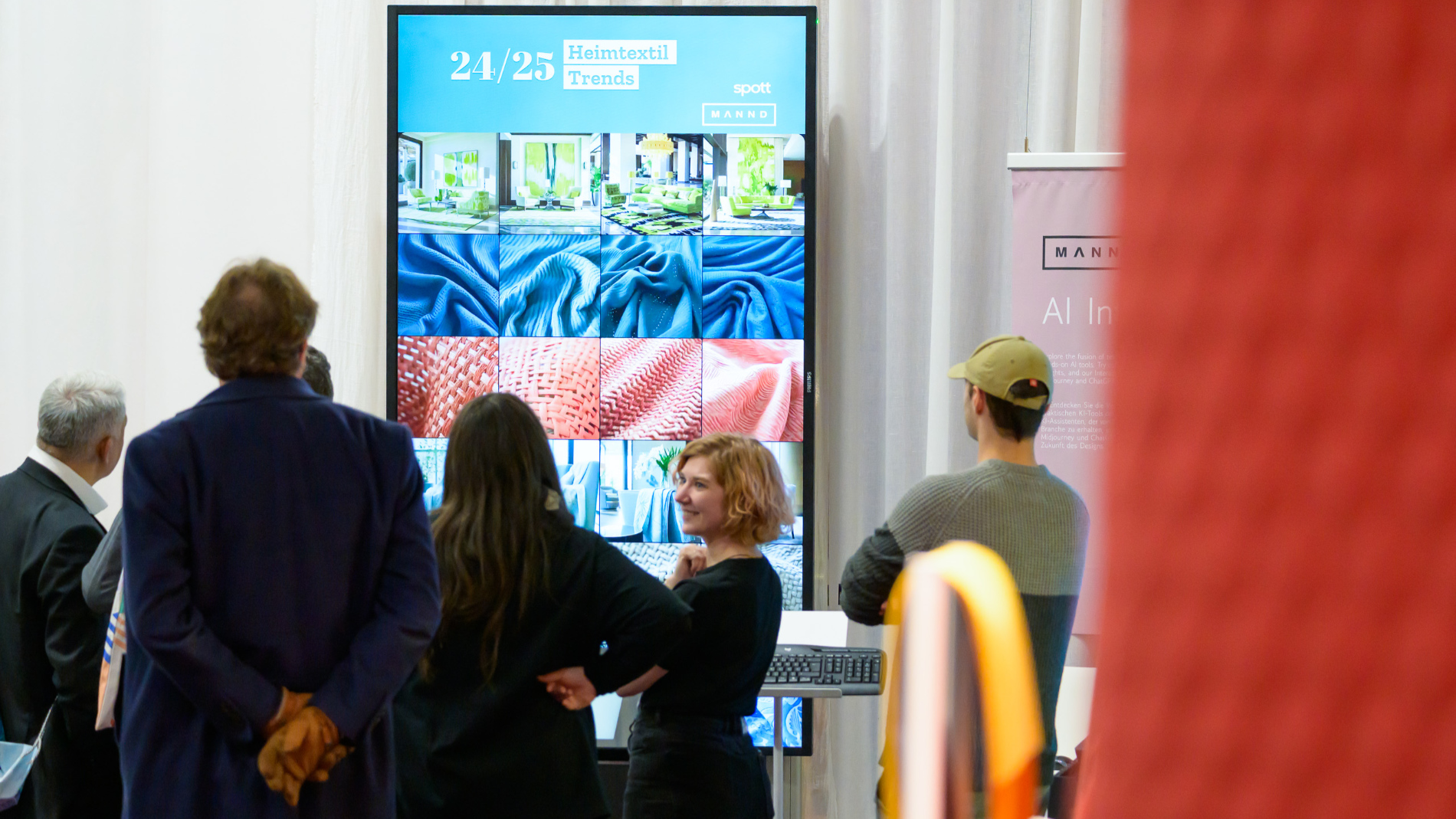 Menschen betrachten  Heimtextil Trends-Präsentation auf großem Bildschirm.