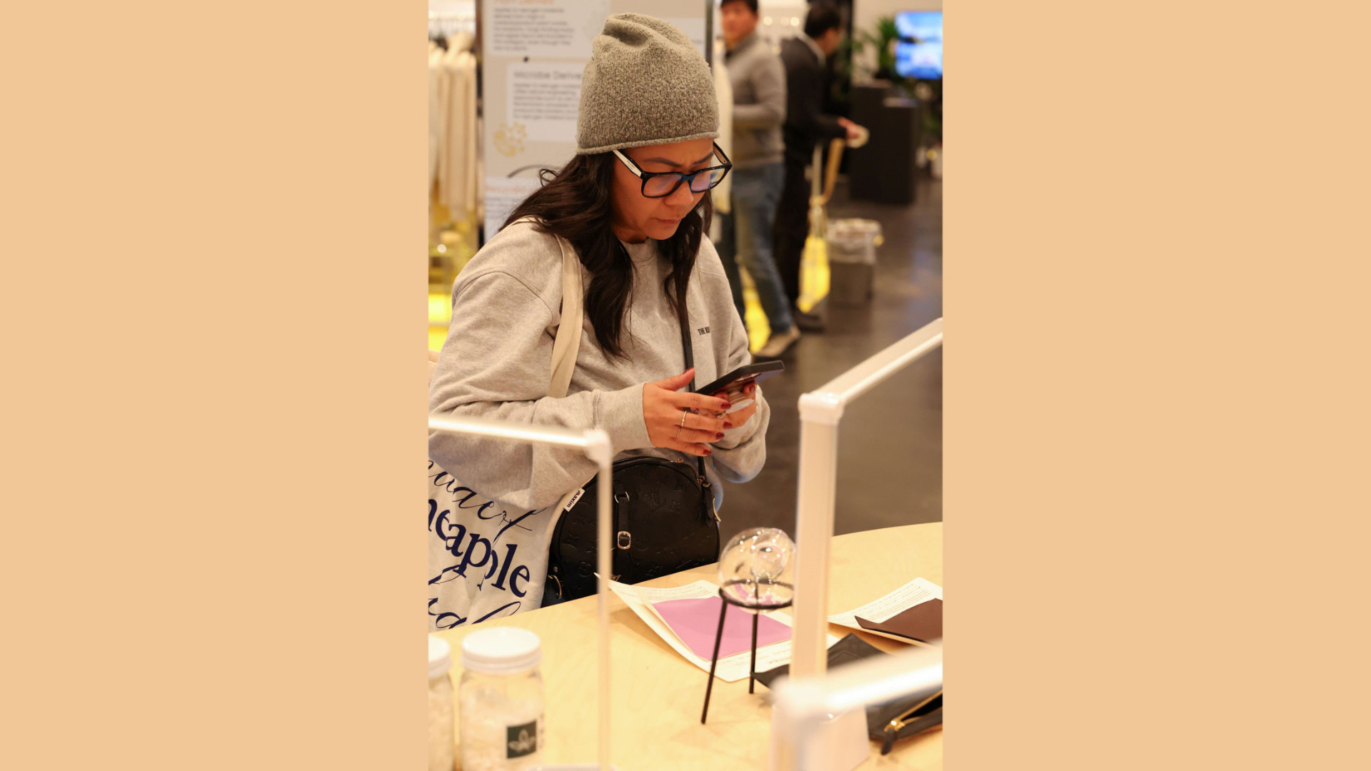 Woman photographing something at an exhibition stand