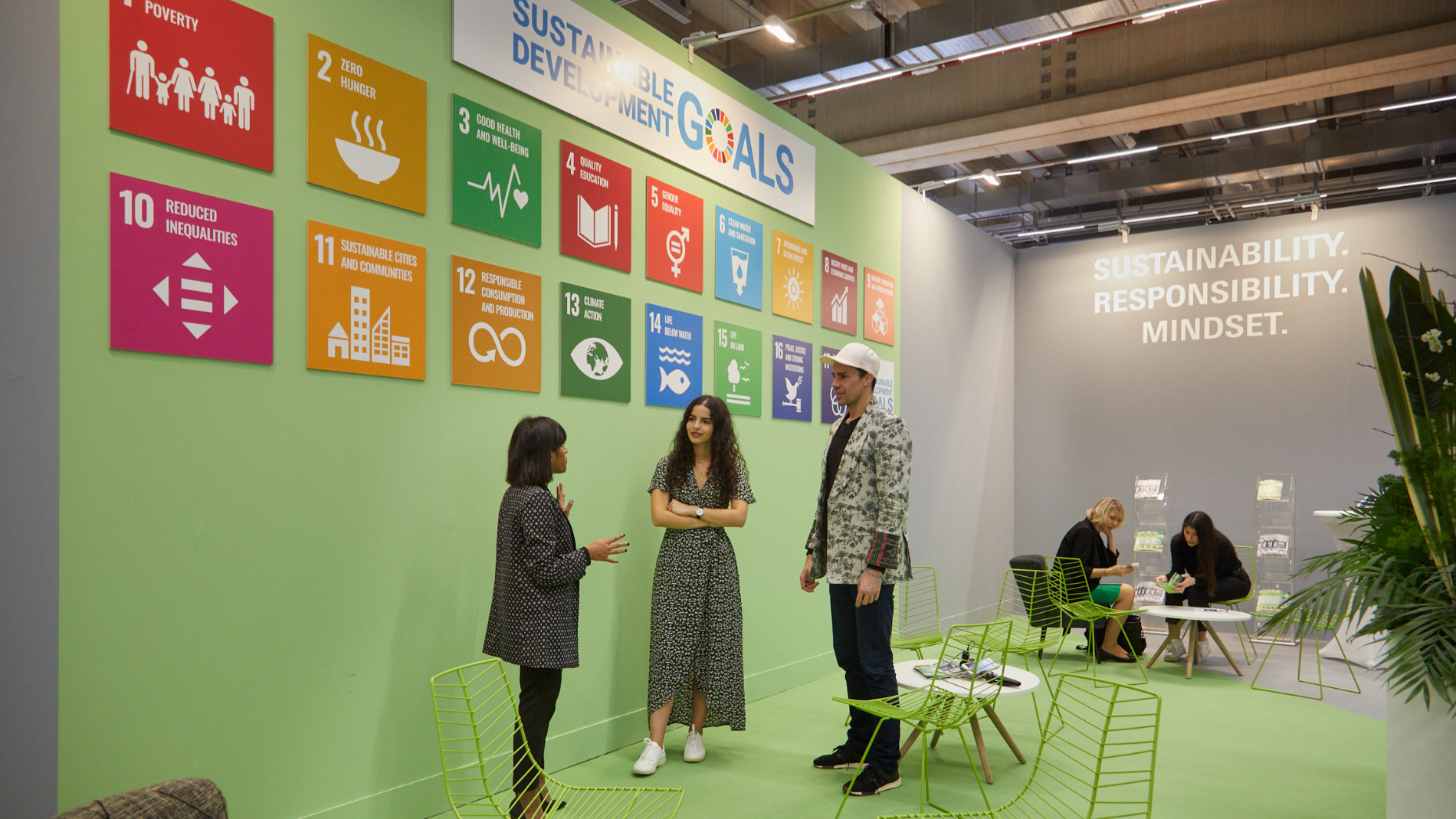 3 Personen vor einer SDG-Wand