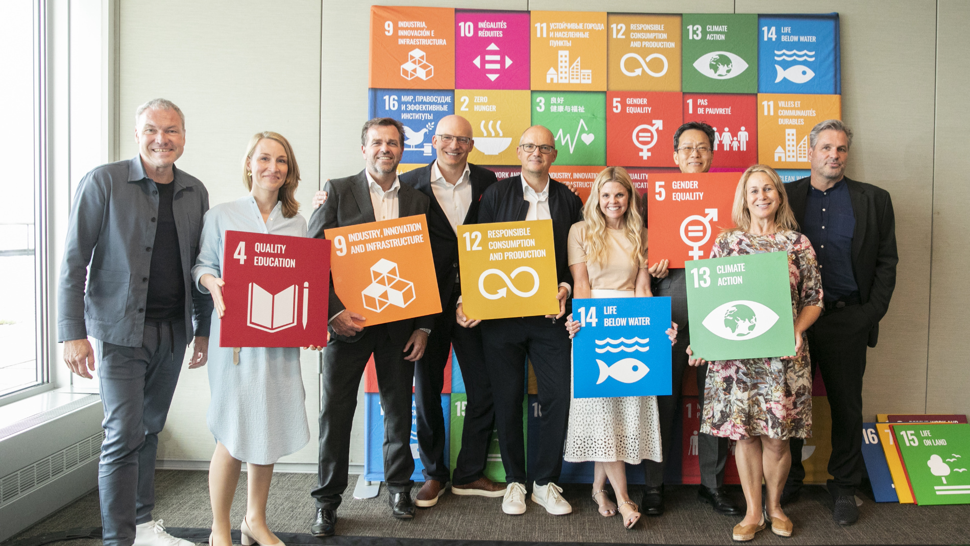 9 people in front of an SDG wall
